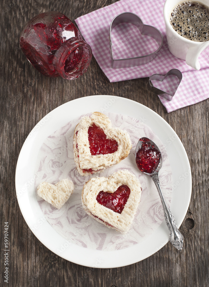 Heart shape sandwich with strawberry jam for breakfast