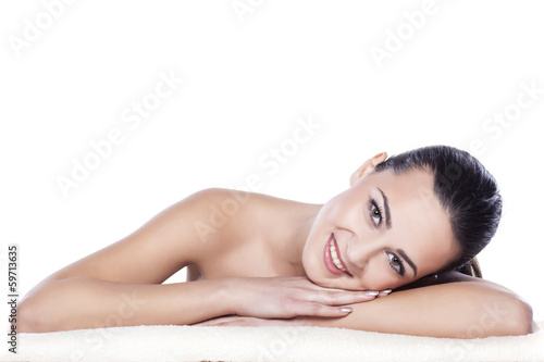 portrait of a beautiful girl lying on a towel on a white