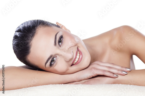 portrait of a beautiful girl lying on a towel on a white