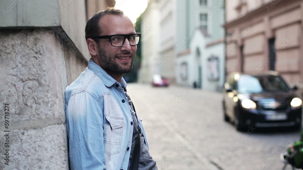 man standing by the brick wall and smiling to the camera man standing by the brick wall and smiling to the camera