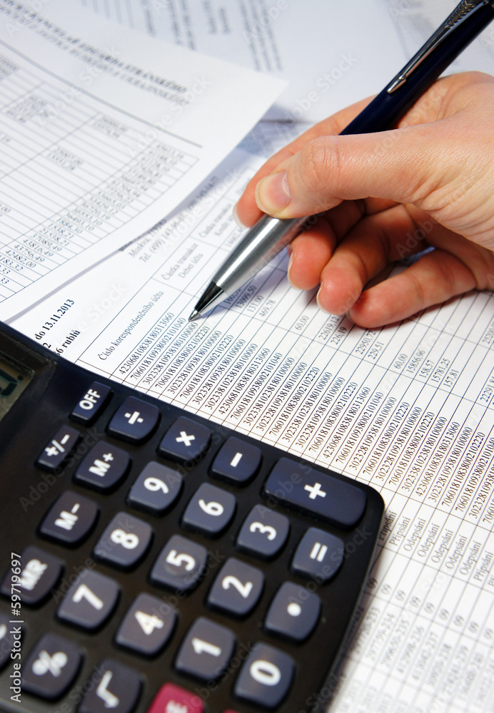 Office table with calculator, pen and accounting document Office table with calculator, pen and accounting document