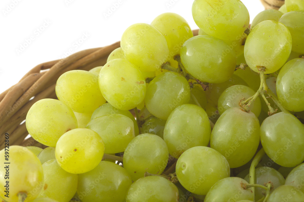 Ripe grape bunches in brown wicker basket isolated close up Ripe grape bunches in brown wicker basket isolated close up