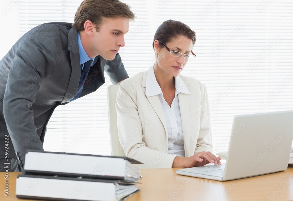 Business couple using laptop at office desk Business couple using laptop at office desk