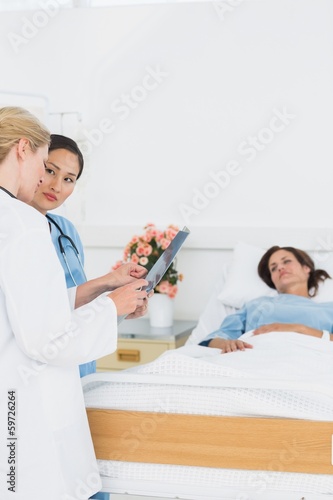 Doctor and surgeon visiting female patient