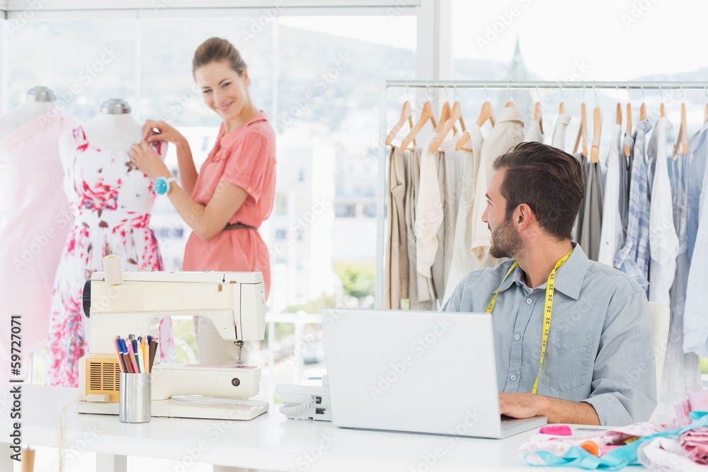 Obraz premium Man using laptop with fashion designer working at studio