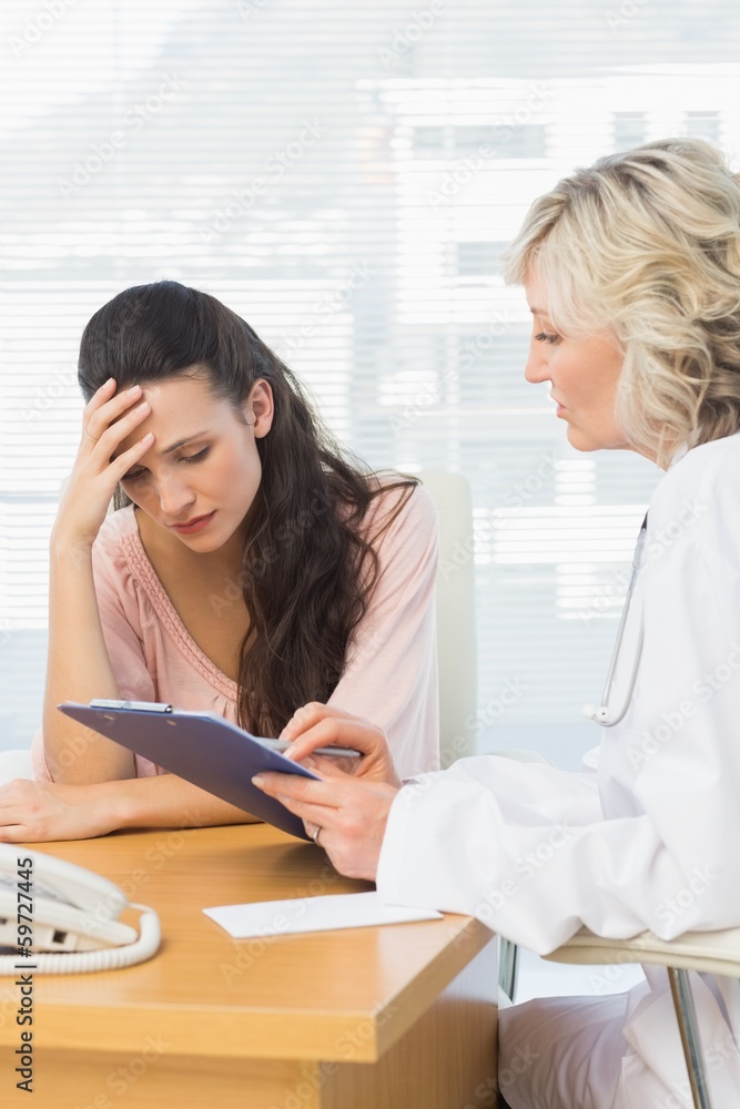 Female doctor discussing reports with patient Female doctor discussing reports with patient