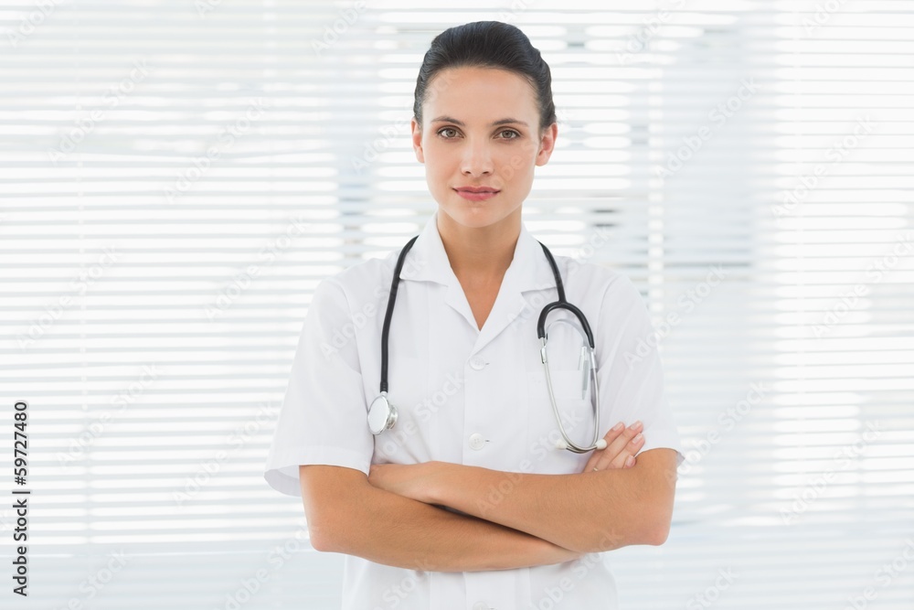 Beautiful female doctor standing with arms crossed Beautiful female doctor standing with arms crossed