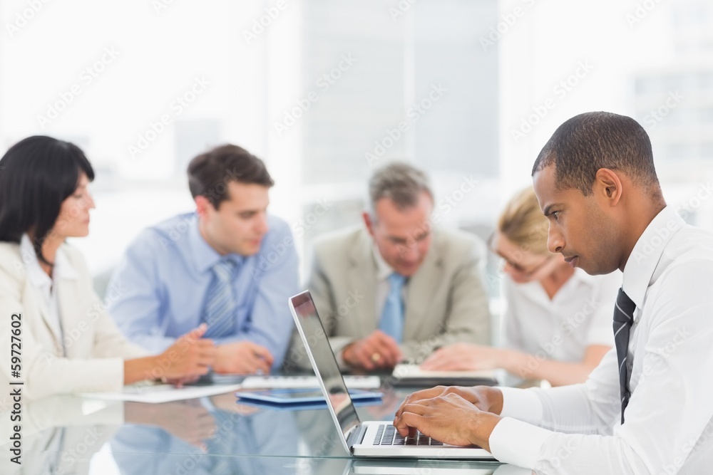 Businessman using laptop during a meeting