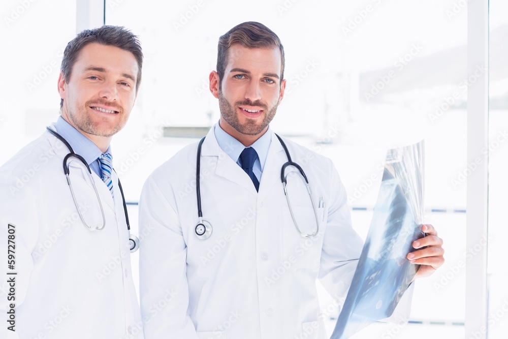 Portrait of two male doctors examining x-ray Portrait of two male doctors examining x-ray