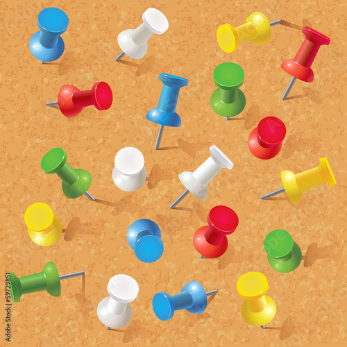 Group of thumbtacks pinned on corkboard