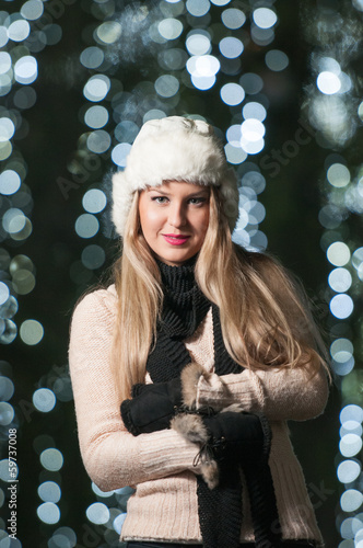Fashionable lady wearing white fur cap and black muffler outdoor