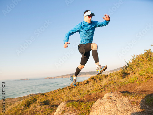 Man practicing trail running in a coastal landscape