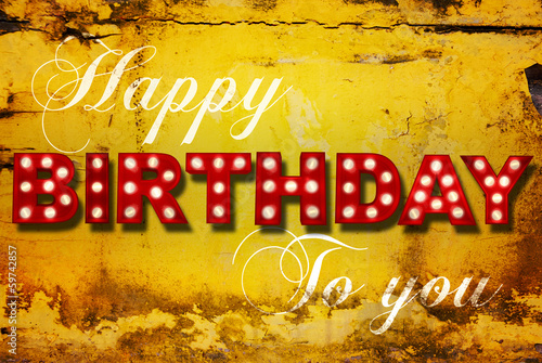 Glowing birthday greetings over distressed yellow paint