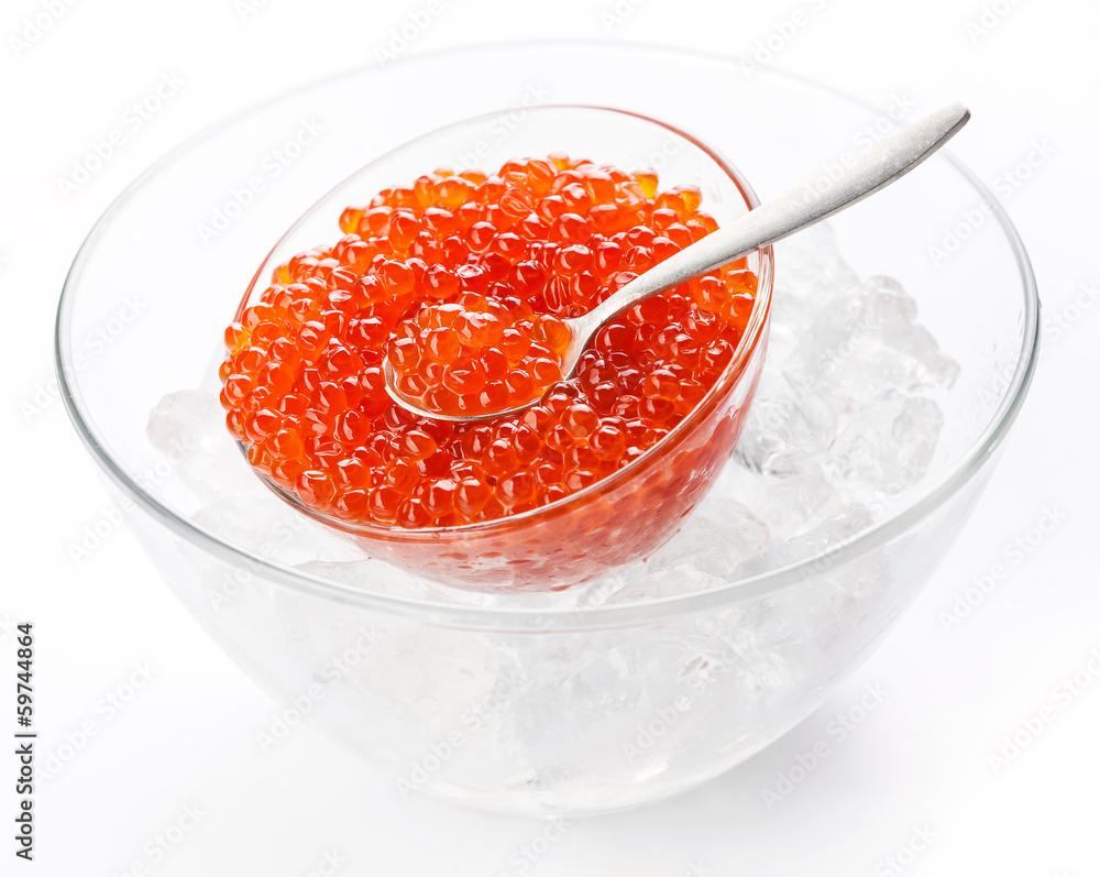 Salmon red caviar in glass bowl and silver spoon on crushed ice Salmon red caviar in glass bowl and silver spoon on crushed ice
