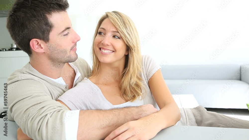 Couple relaxing in sofa and looking away Couple relaxing in sofa and looking away