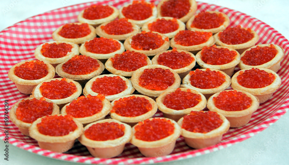 Tartlets with red caviar on a checkered plate Tartlets with red caviar on a checkered plate
