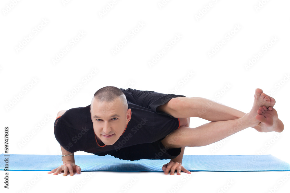 Smiling flexible man posing in difficult yoga pose Smiling flexible man posing in difficult yoga pose