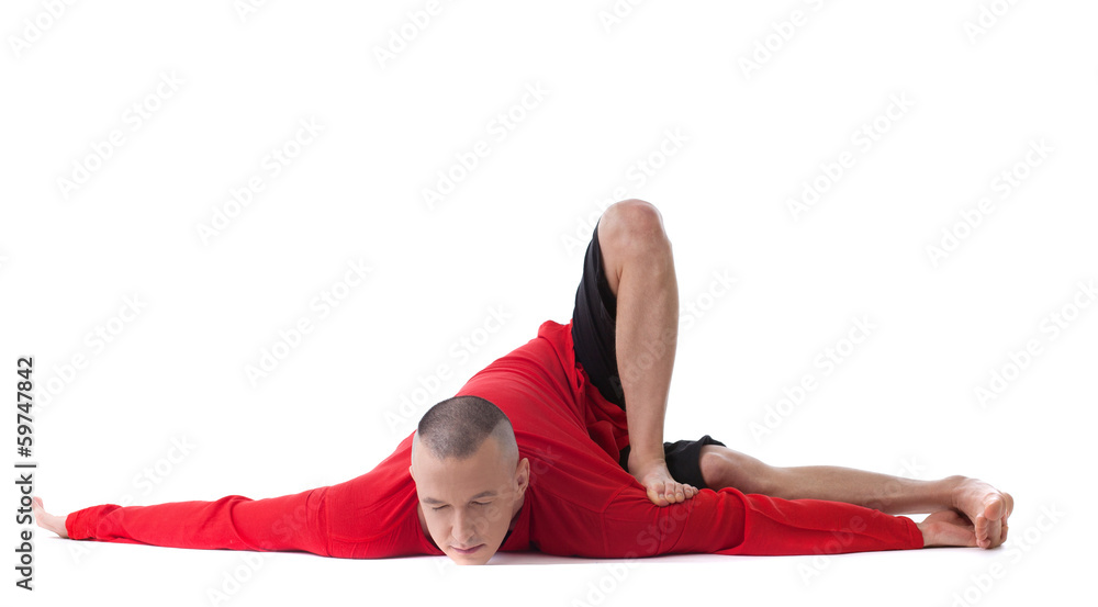 Fit muscular flexible man posing in difficult yoga pose Stock