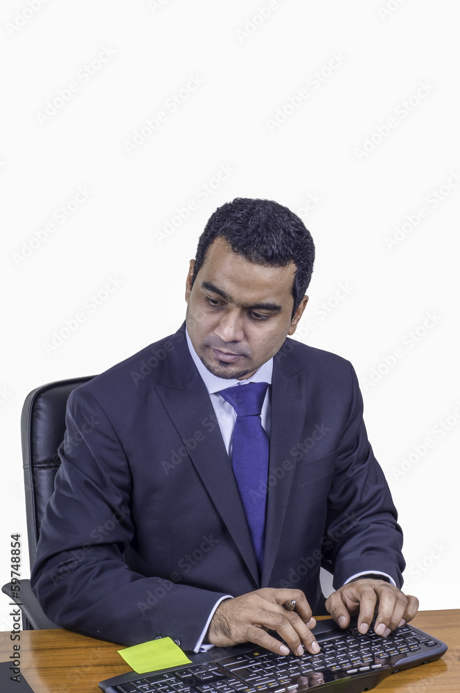 businessman typing on a keyboard and looking at monitor