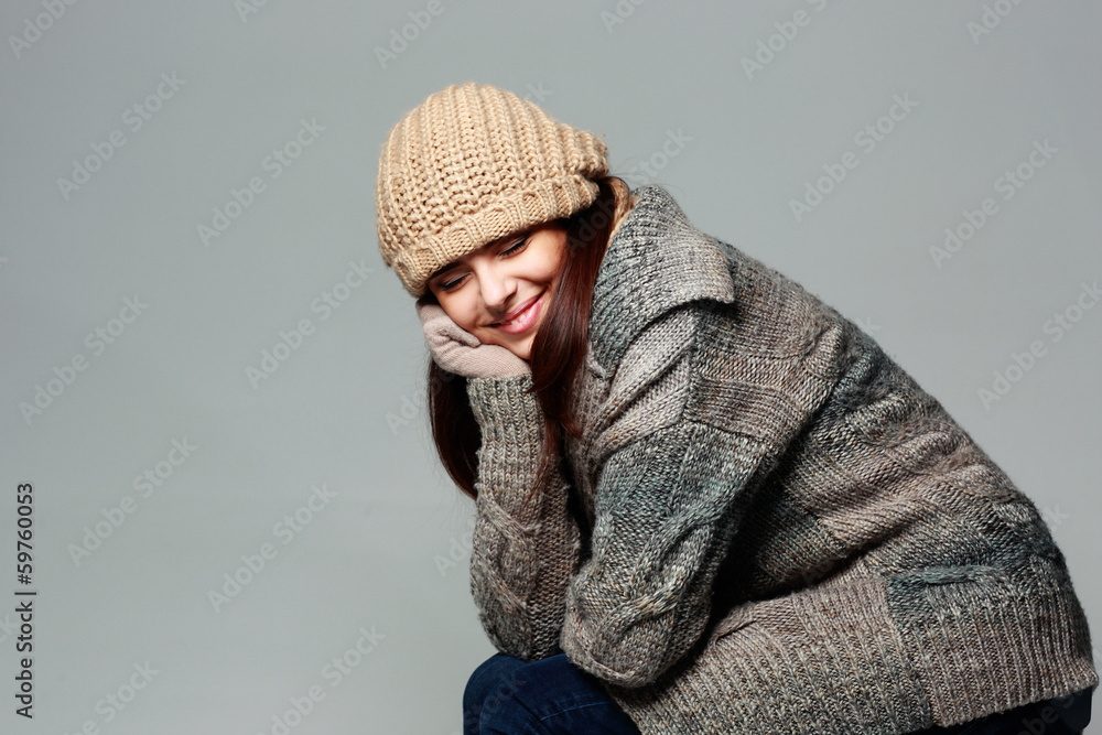 Young happy woman in warm winter outfit on gray background Young happy woman in warm winter outfit on gray background