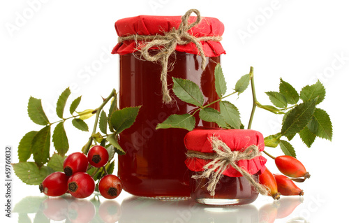 jars with hip roses jam and ripe berries, isolated on white photo