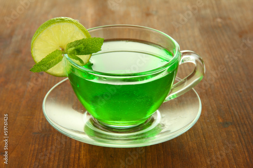 Transparent cup of green tea with lime and mint