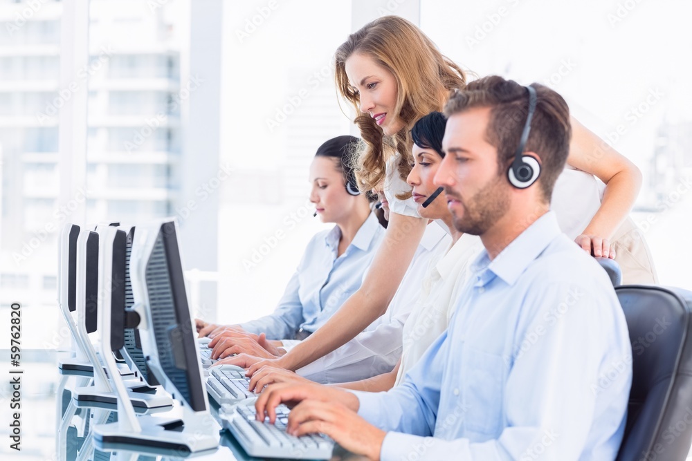 Obraz premium Manager and executives with headsets using computers