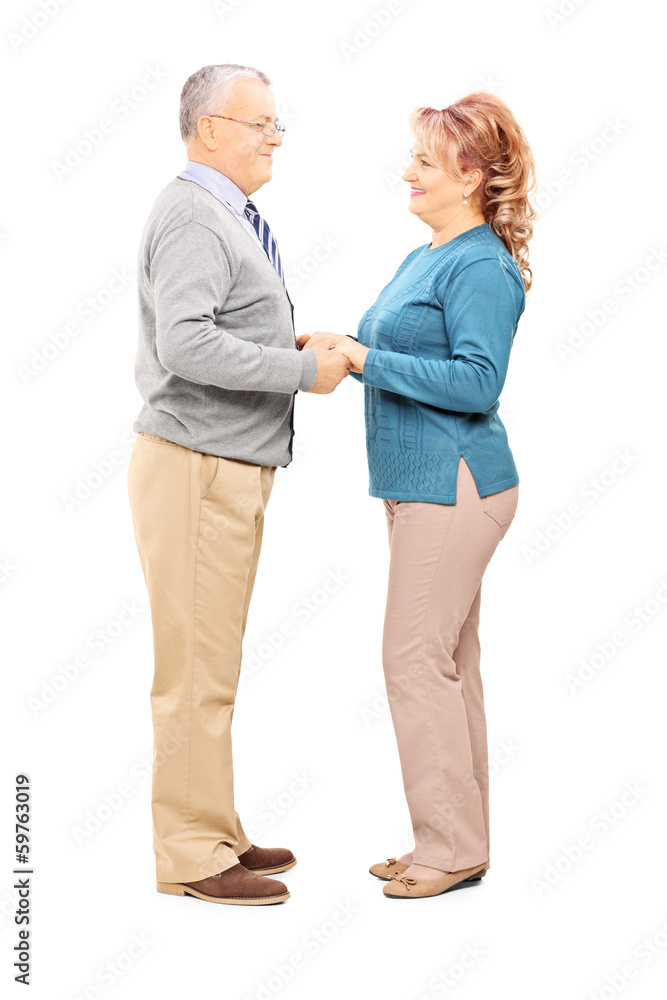 Happy mature couple holding hands and looking each other Happy mature couple holding hands and looking each other
