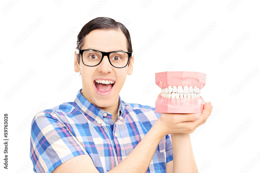 Guy holding dentures made out of plaster cast looking at camera Guy holding dentures made out of plaster cast looking at camera