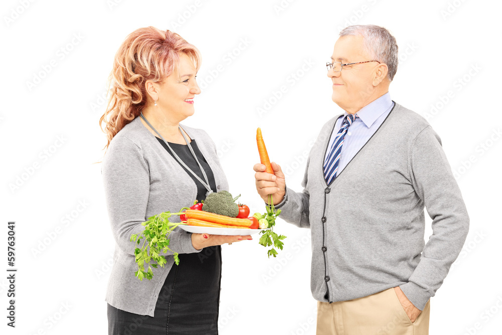 Middle aged couple standing close together and holding a healthy Middle aged couple standing close together and holding a healthy