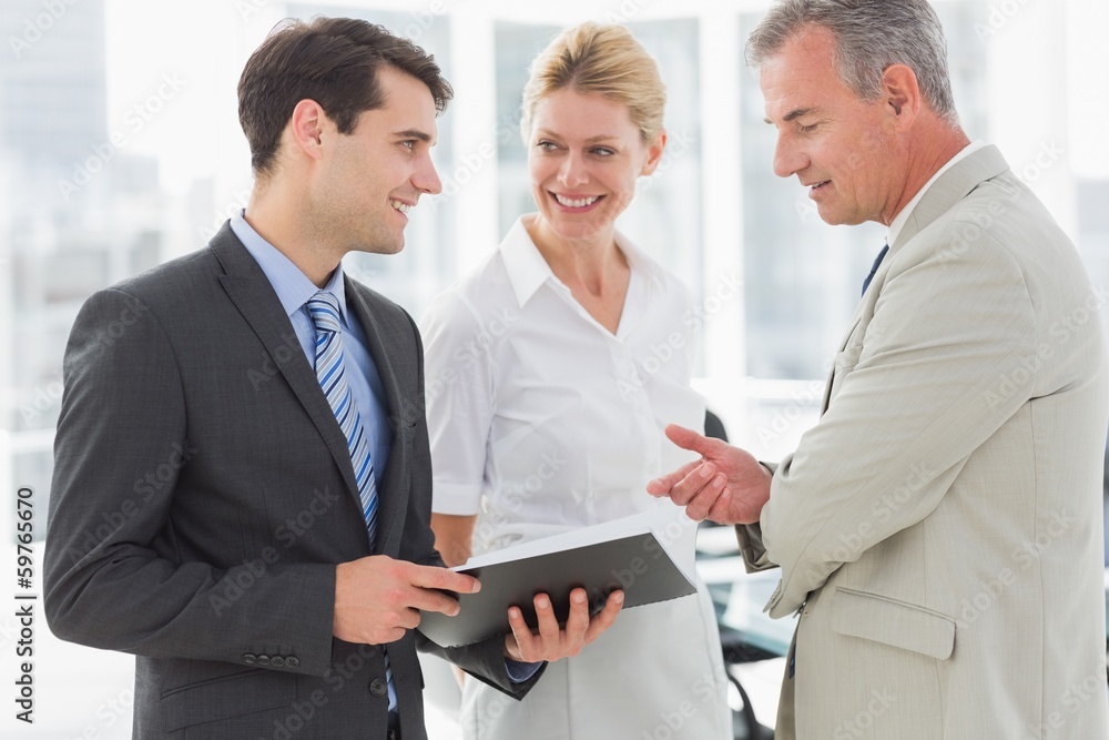 Smiling business team going over documents Smiling business team going over documents