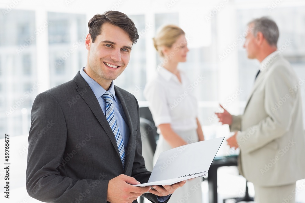 Businessman reading over a document smiling at camera Businessman reading over a document smiling at camera