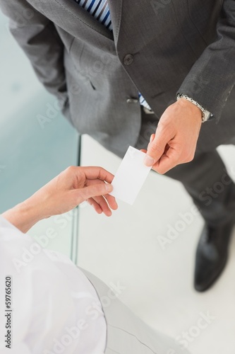 Businessman handing businesswoman his card