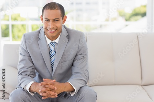 Smiling businessman sitting on couch