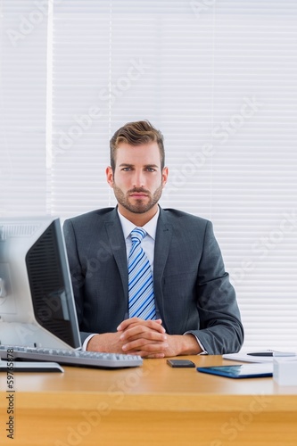 Serious businessman with computer at office desk