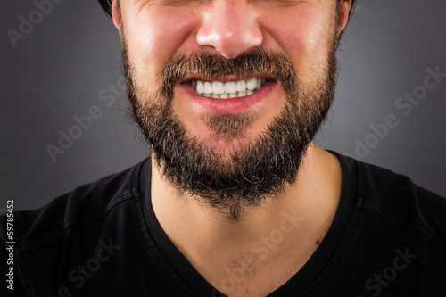 Closeup of stressed man mouth isolated on gray background