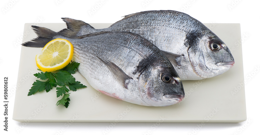 Fresh fish with slice of lemon and parsley on plate isolated Fresh fish with slice of lemon and parsley on plate isolated