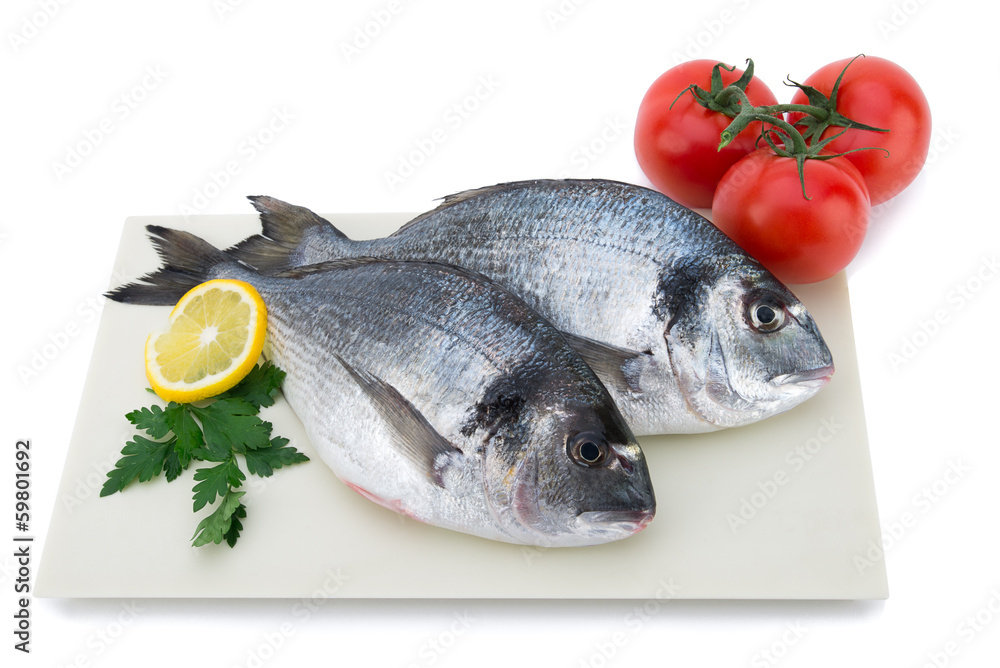Fresh raw fish with vegetables on plate isolated on white Fresh raw fish with vegetables on plate isolated on white