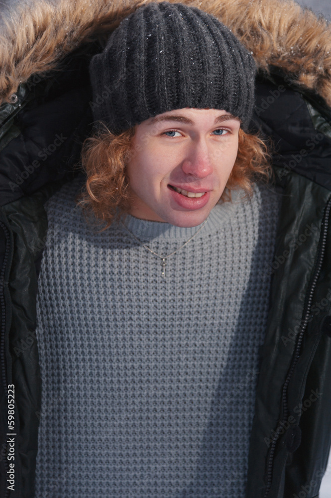 Young man holds his jacket in winter Park Young man holds his jacket in winter Park
