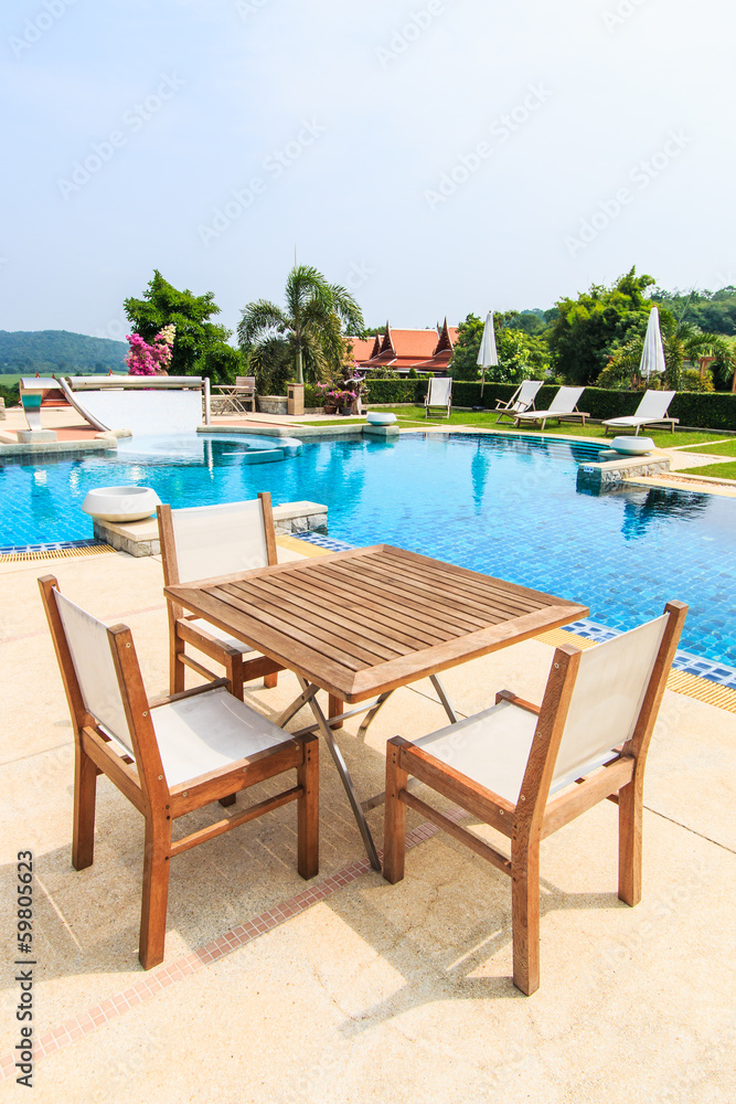 Table and chairs besides the pool