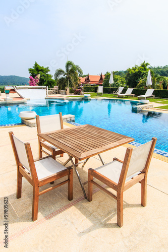 Table and chairs besides the pool © Photo Gallery