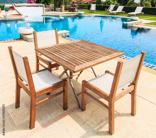 Table and chairs besides the pool