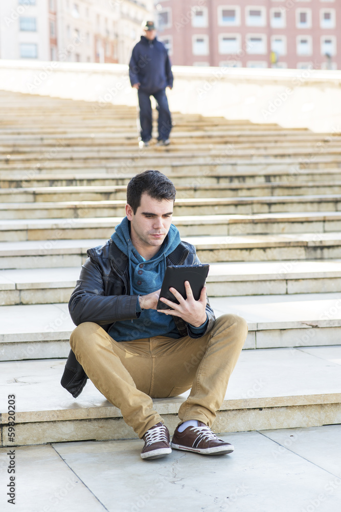 Student using tablet computer in public space.