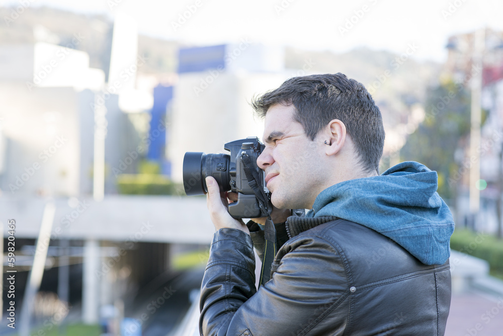 Portrait of photographer with camera in action in the street. Portrait of photographer with camera in action in the street.