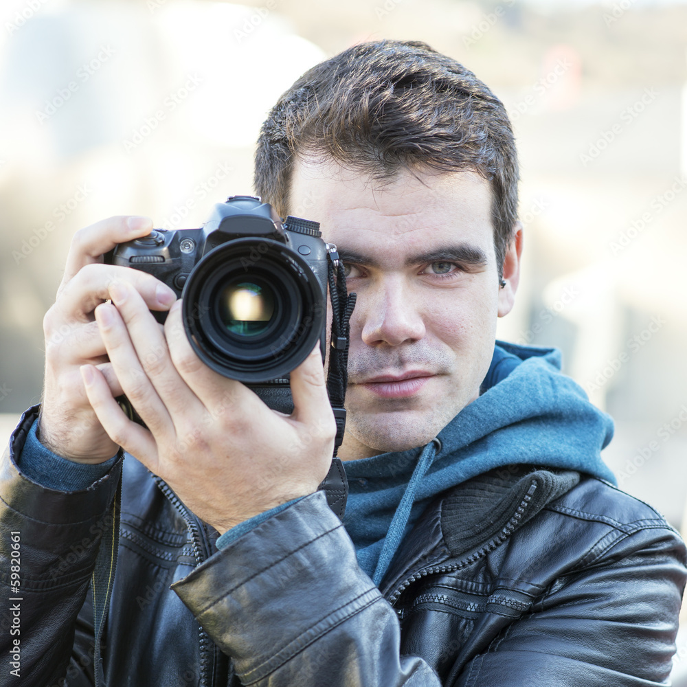 Portrait of photographer using professional camera.