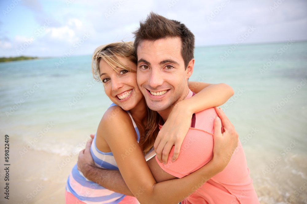 Young cheerful couple having fun at the beach