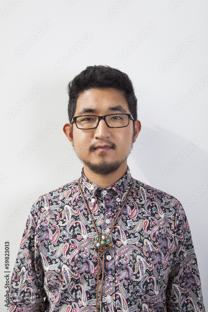 Fototapeta premium Portrait of young man wearing eyeglasses standing against white background