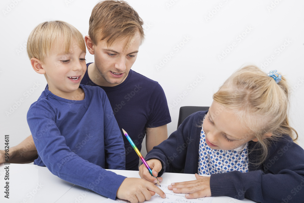 Father and son looking at girl studying at table Father and son looking at girl studying at table