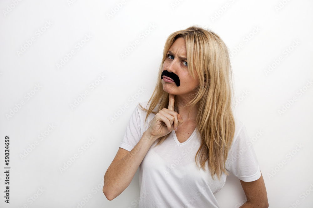 Portrait of confused in fake mustache against white background Portrait of confused in fake mustache against white background