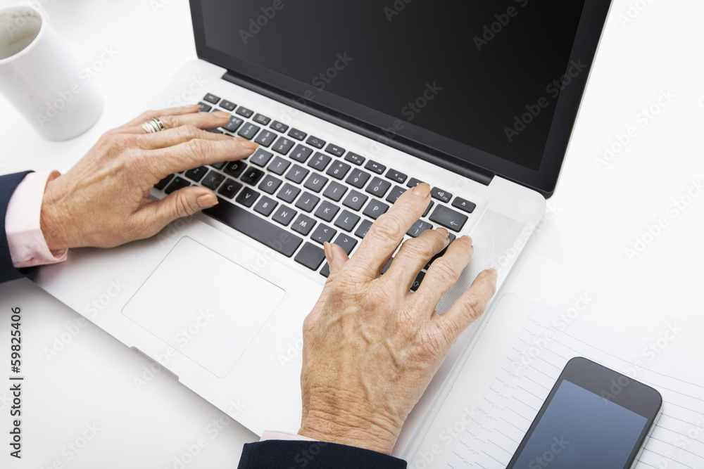 Senior businesswoman using laptop at office desk Senior businesswoman using laptop at office desk